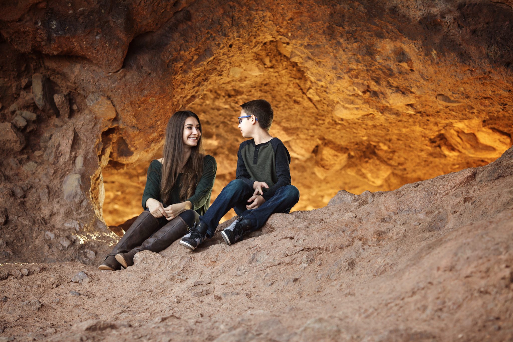 Sibling teens sit at the Hole in the Rock for portratis