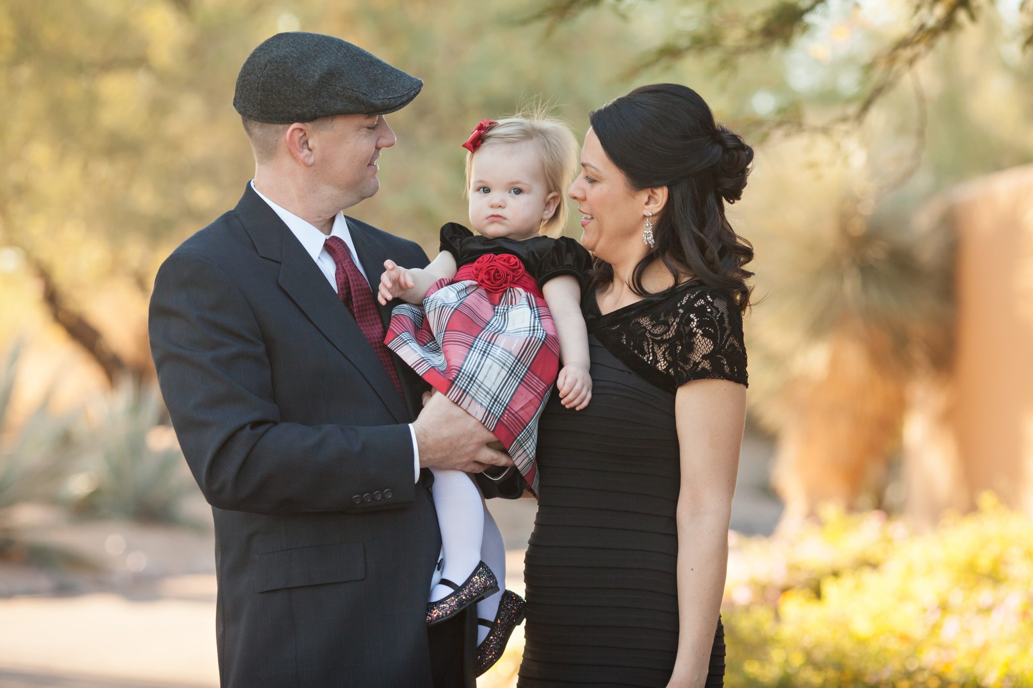 Family of three with toddler girl pose for a family portrait by best Phoenix photographer