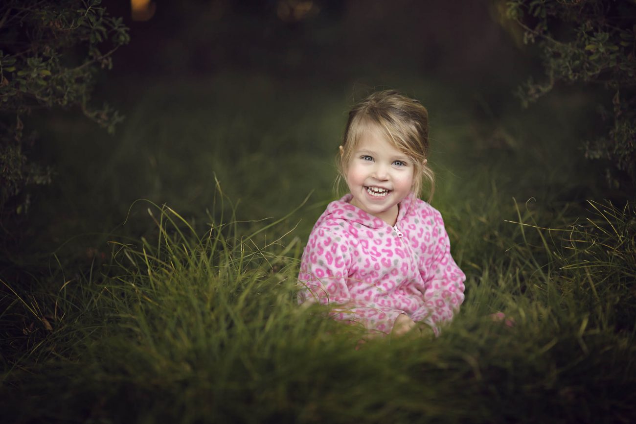 3 year old portrait taken in a field of grass