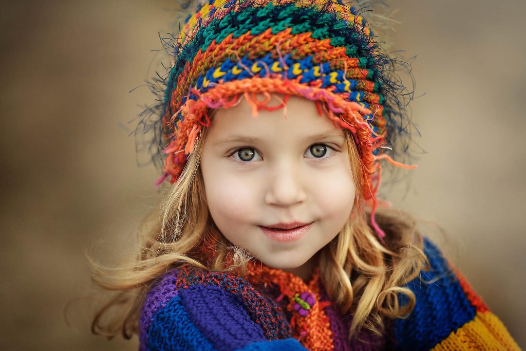 Four year old girl close up portrait teknin Ahwatukee with brightly colored handmade sweater and hat
