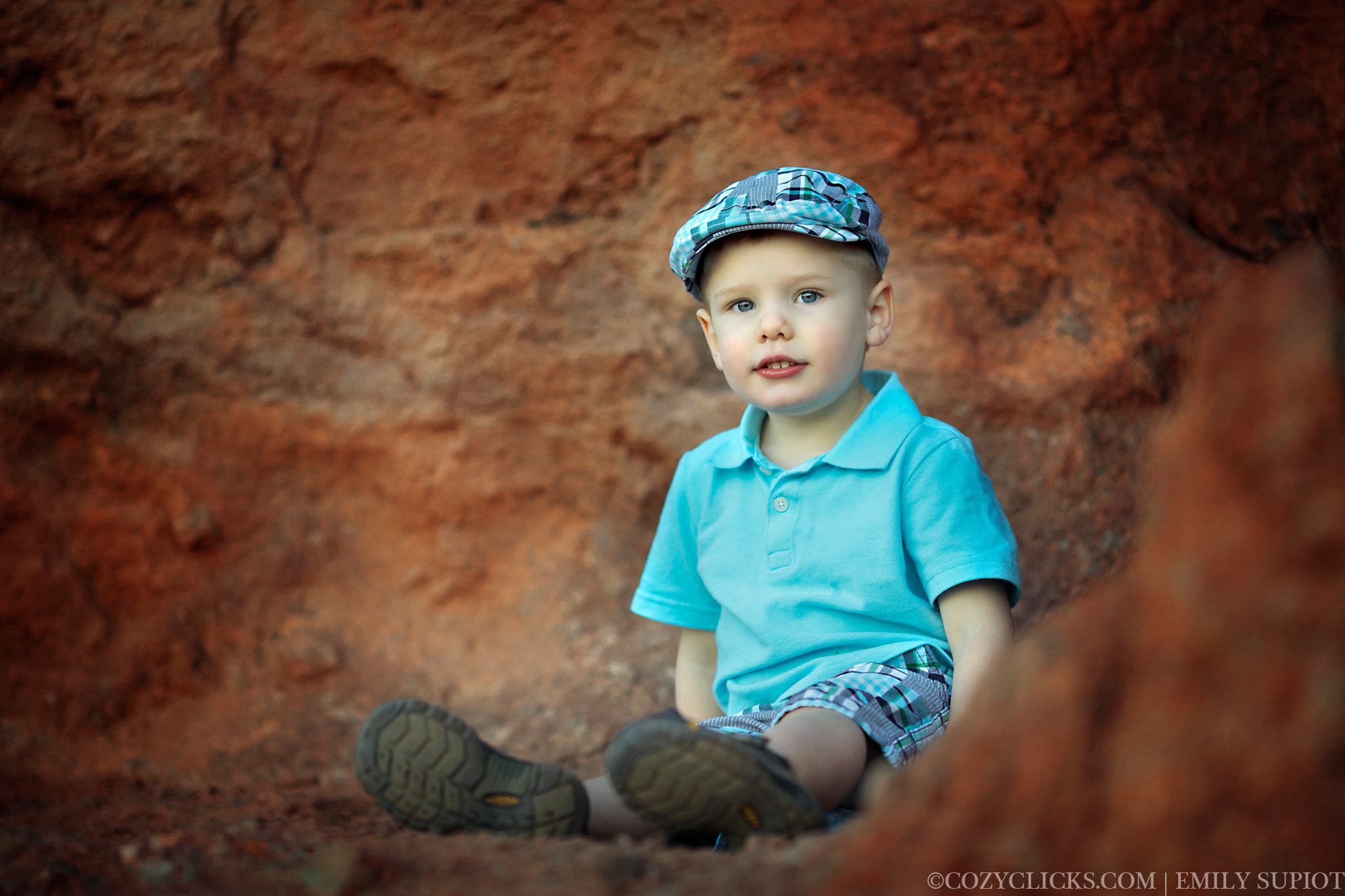 Toddler boy sitting in papago park red rock mountain 