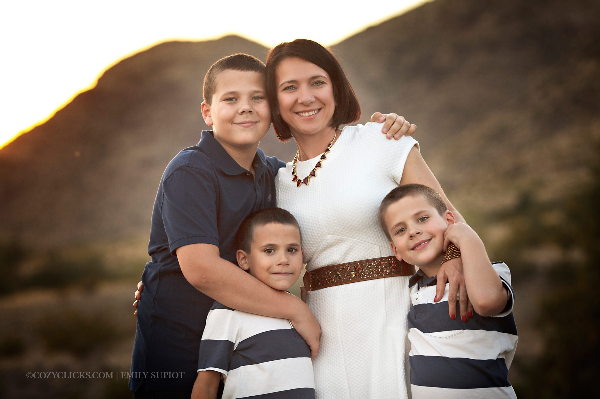 A mom and her boys pose for a photo at sunset near the mountain in Ahwatukee