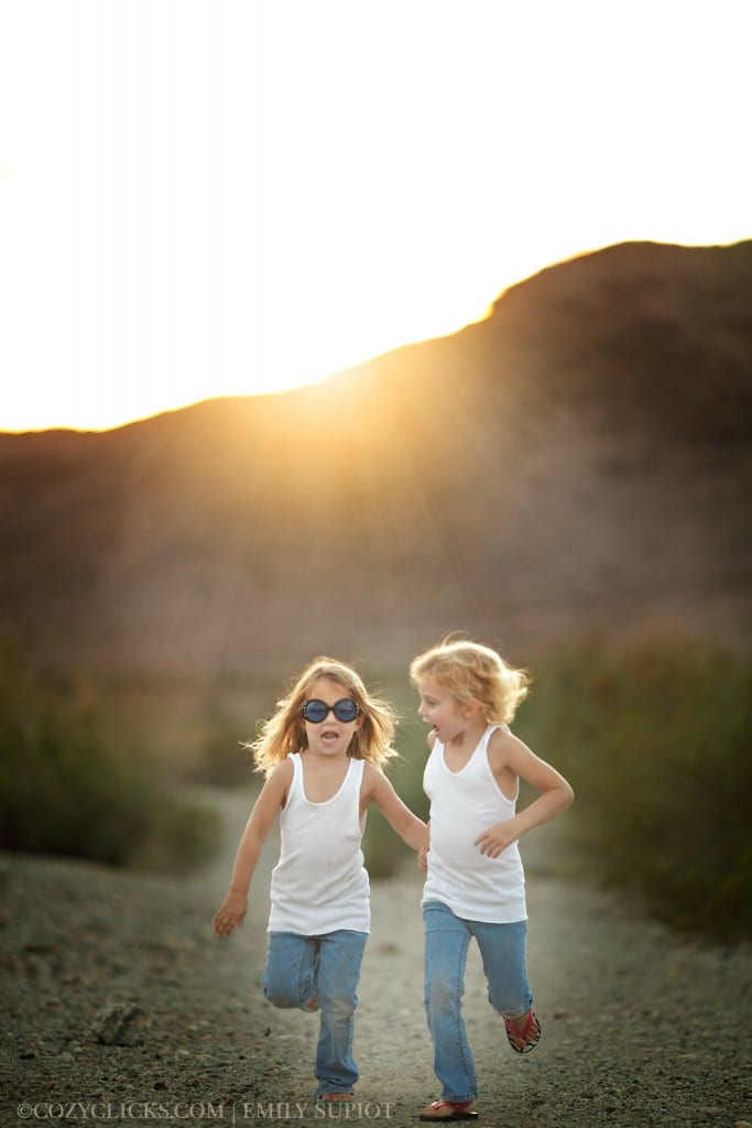 Young sisters running down the mountain in Ahwatukee and laughing