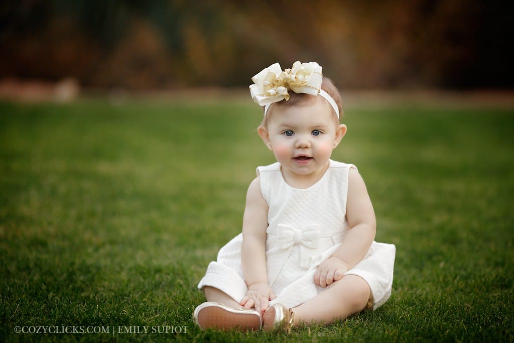 One year old girl portrait in white dress taken at DC Ranch green grass area in Scottsdale