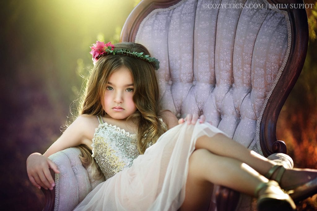 Child portriat takenin styled session with desginer dree, flower crown and vintage chair in Phoenix, AZ