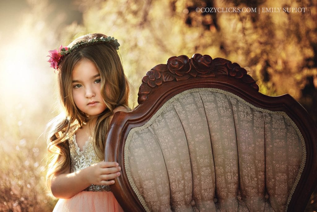 Styled children's photo session of young girl with vintage chair and flower crown
