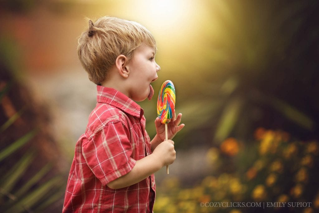 Candid photograph of tow year old licking a lollipop for his two year portrait
