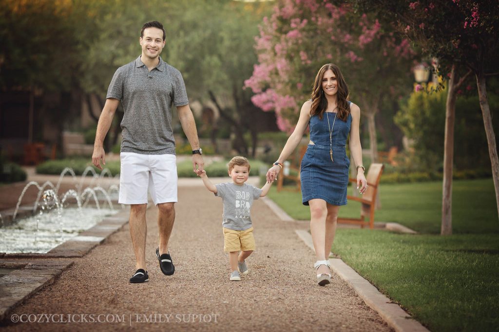 Family of three portrait walking down flower path in Scottsdale, AZ 