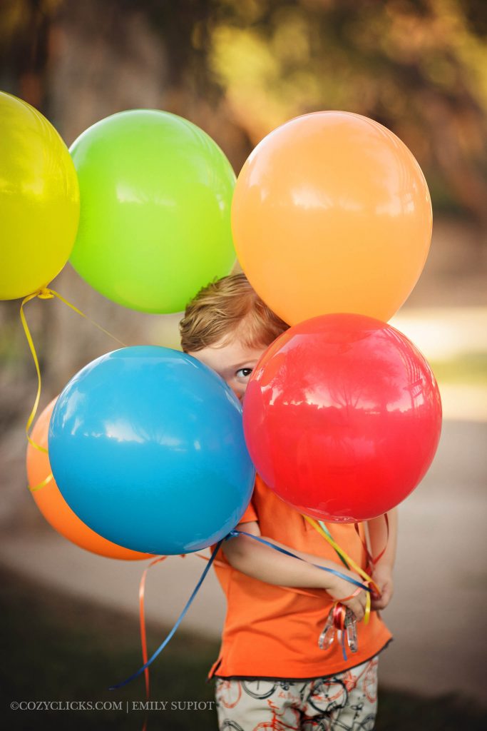 Super cute two year old portrait shot with colored ballons