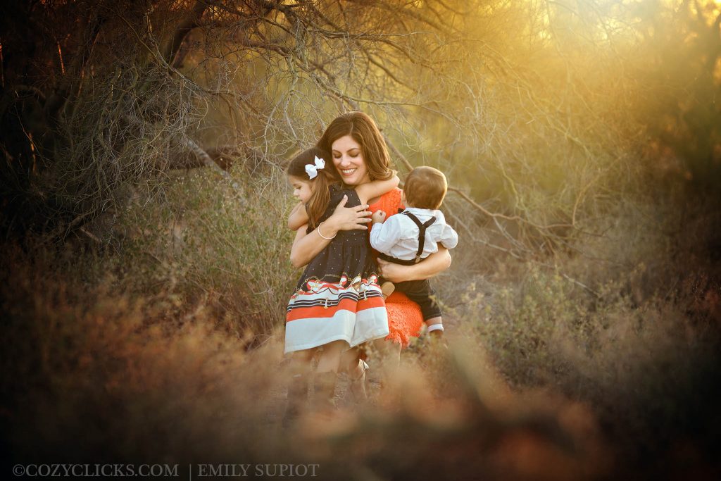 Mother hugging her tow children in fmaily portait taken in Scottsdale at the McDowell Sonoran Preserve