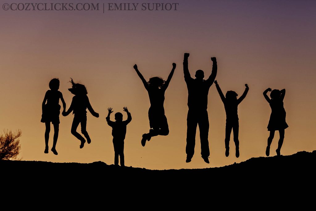 Silhouette photo of family of six jumping at sunset in Phoenix Arizona