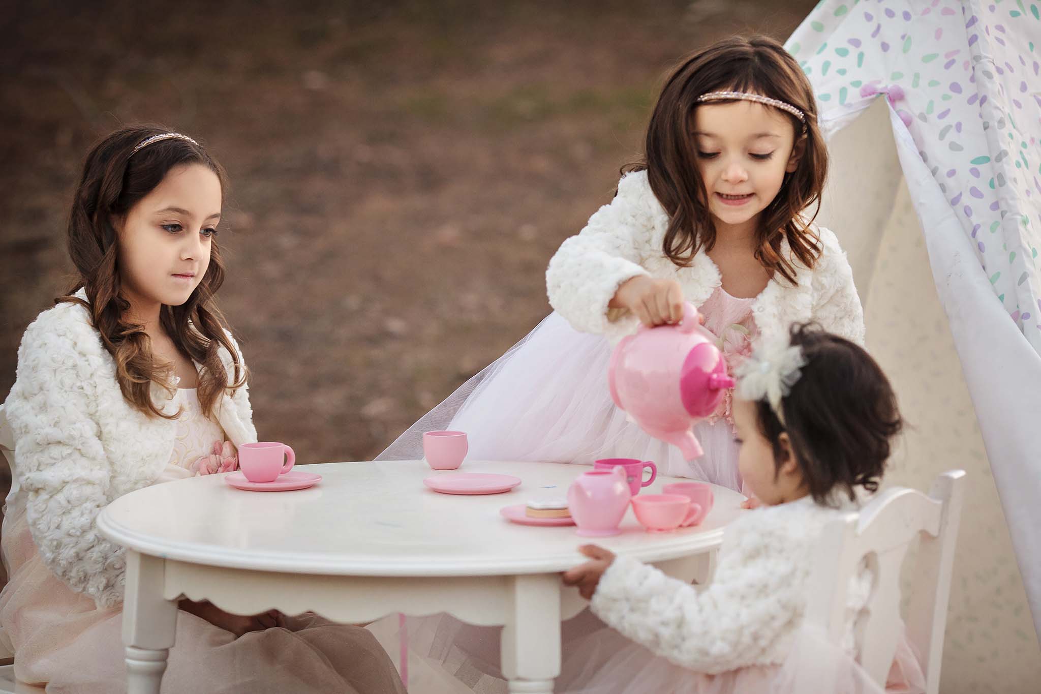 Sisters having a tea party in this portrait taken in Phoenix at Coon Bluff