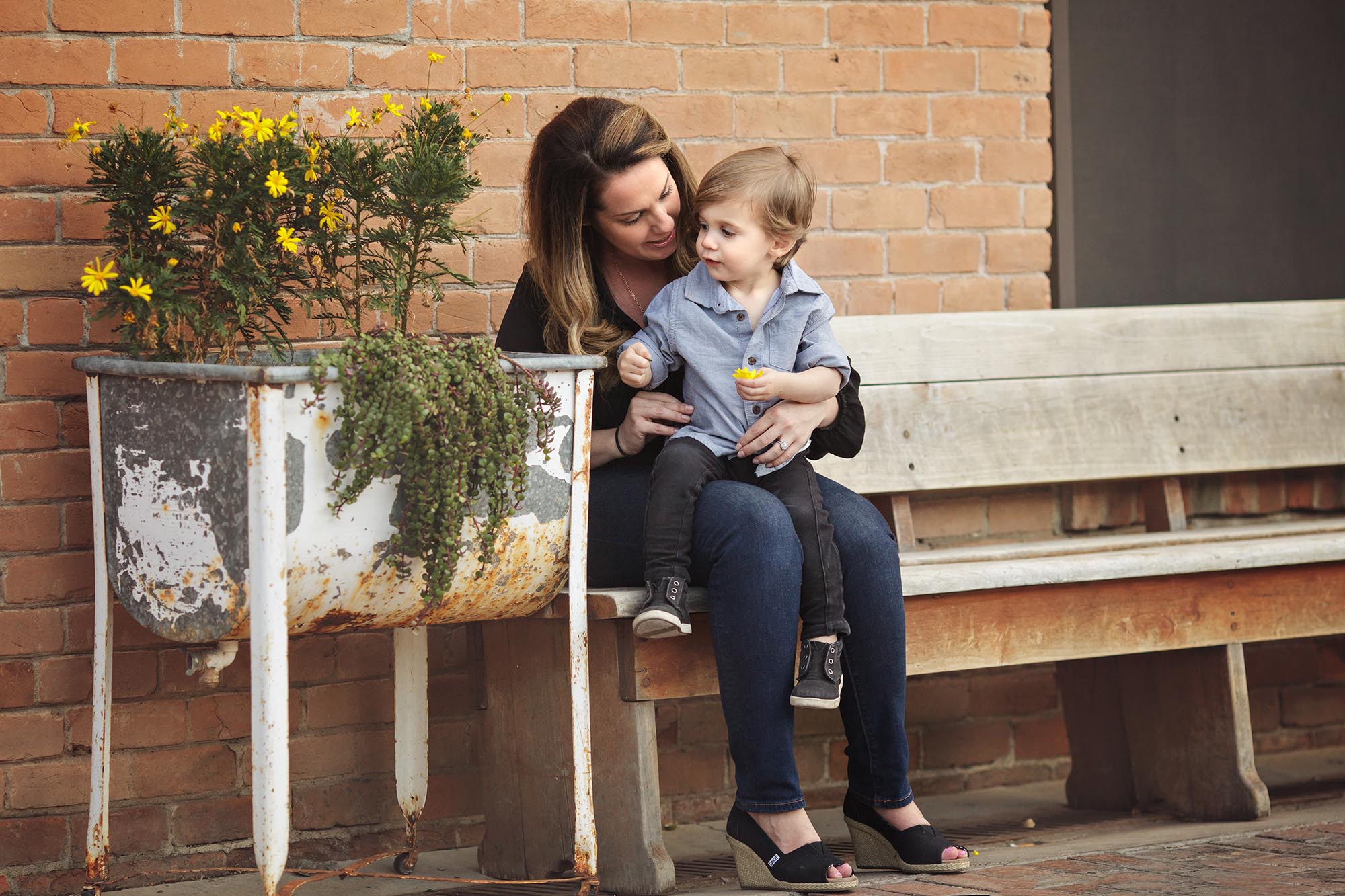 Mom and son together in family picture in Phoenix near brick wall