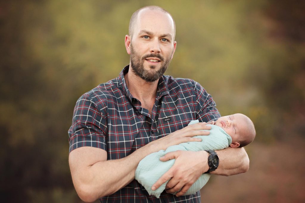 Dad with his newborn son stand together for a Phoenix Newborn and Family Photographer portrait by best family photographer in Phoenix
