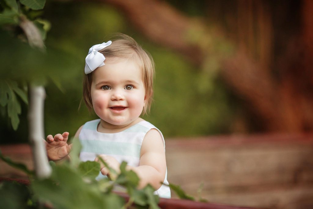 Smiling one year old girl takes pictures for birthday in Glendale.