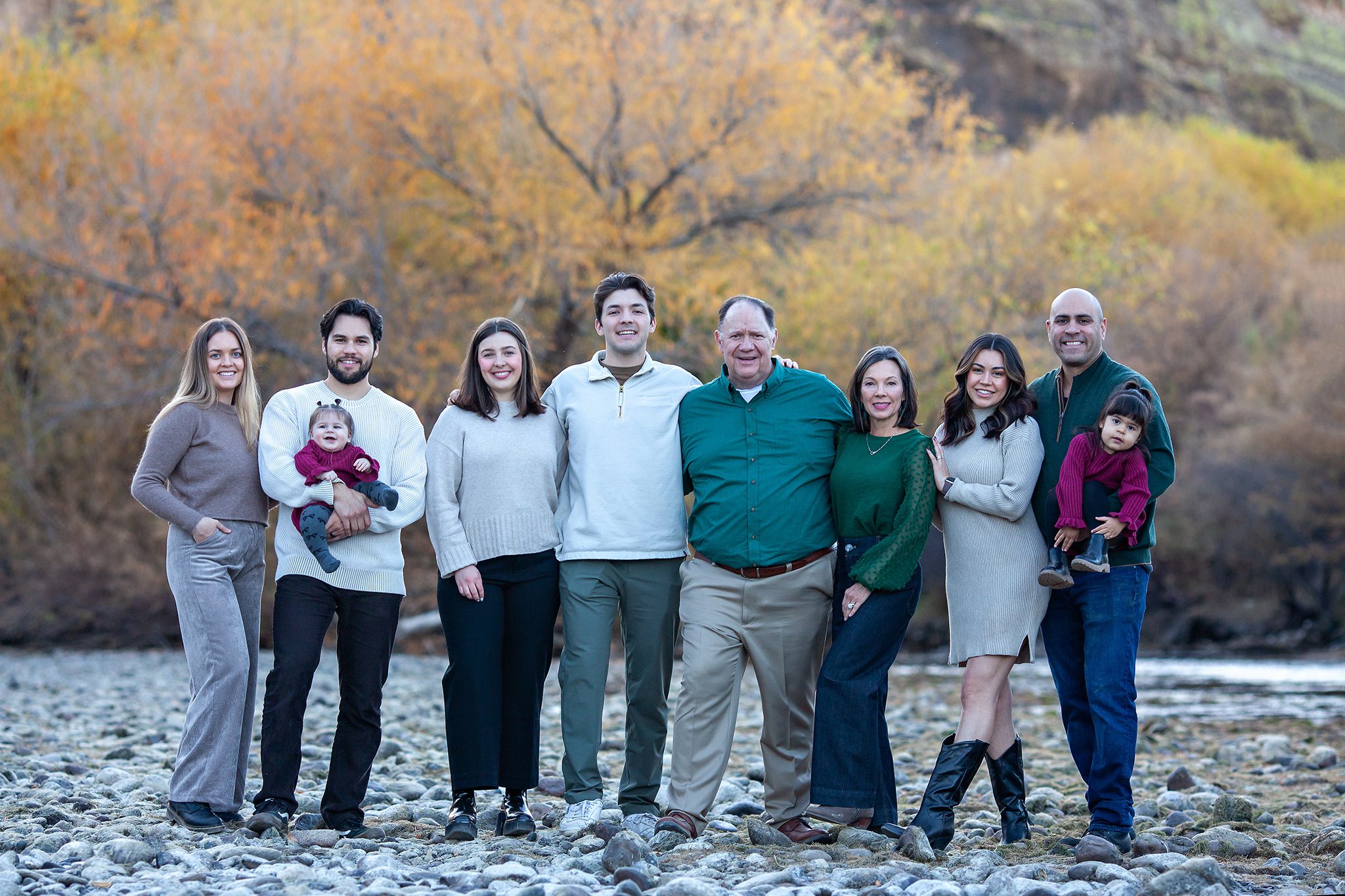 Extended family posing together at Coon Bluff Campground with the Salt River in the background, bathed in golden hour light
