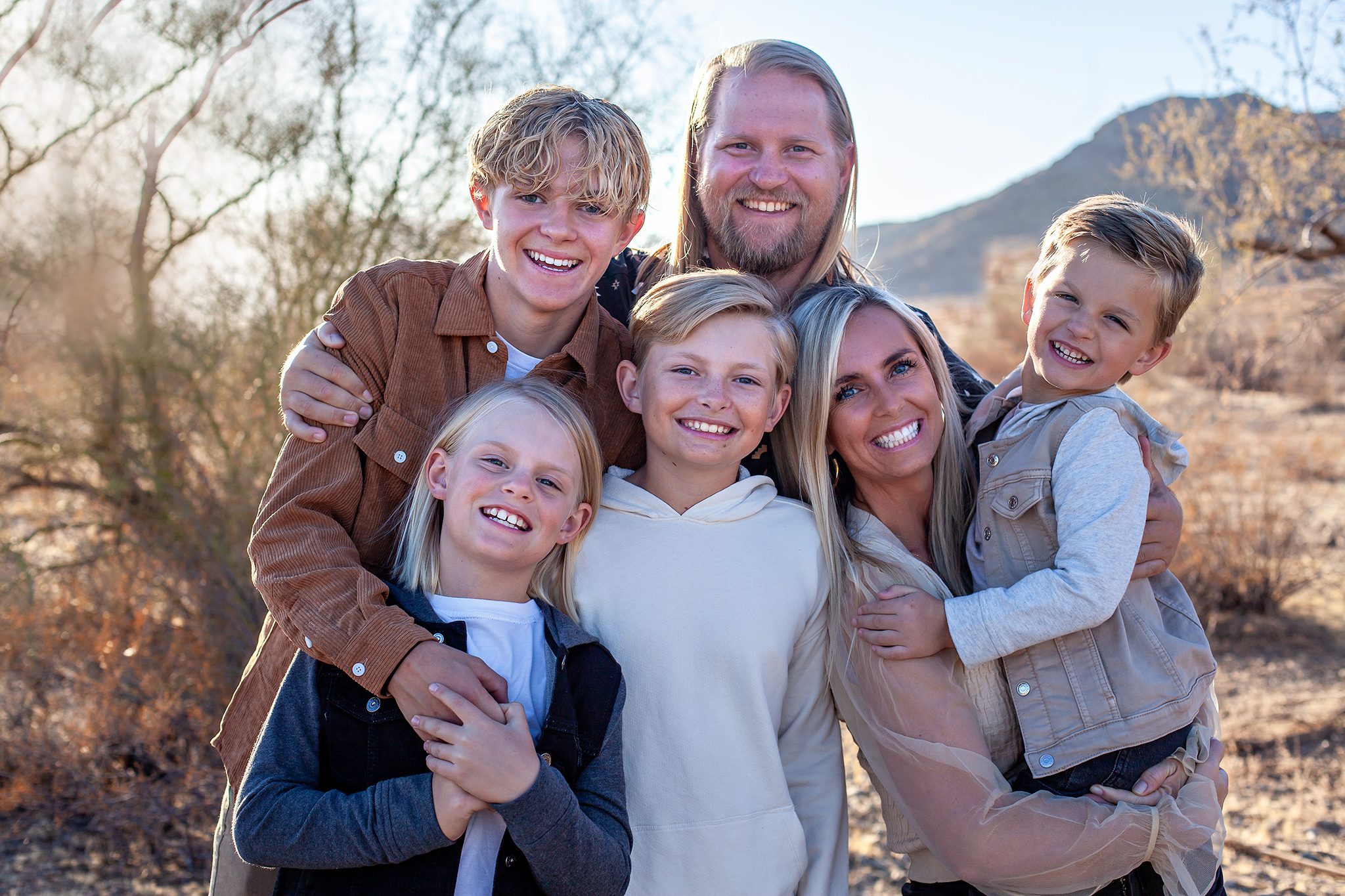 Large family posing in the Phoenix desert for an extended family photo session with stunning mountain views