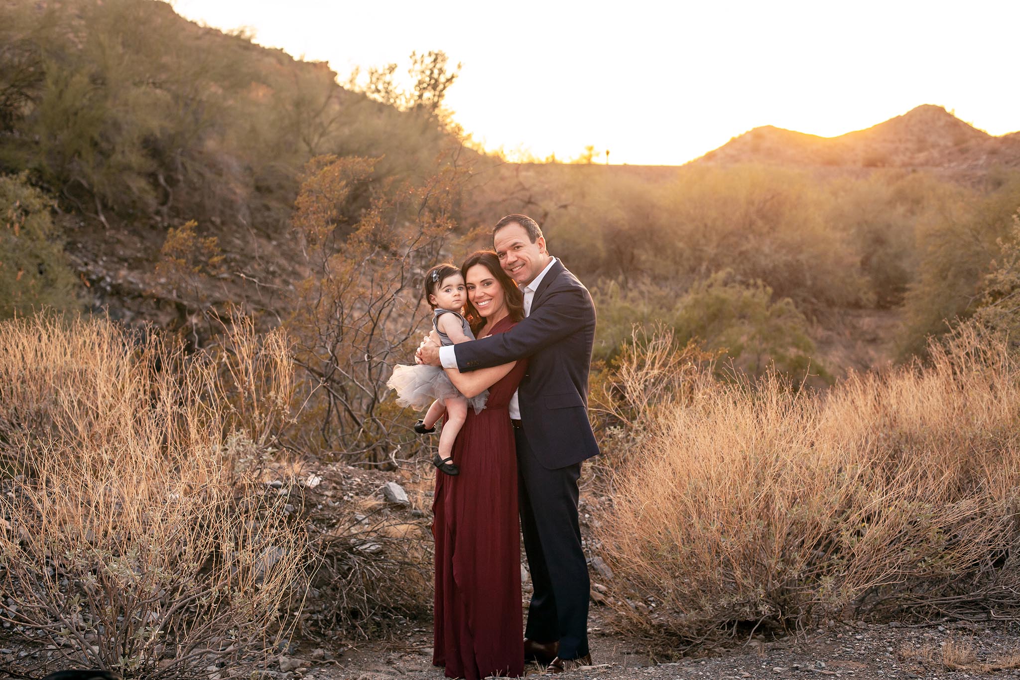 Family of three poses for family photo in the Phoenix Desert