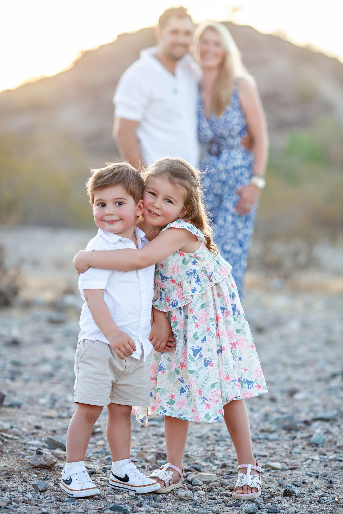 Parents and children smiling in front of historic stone wall at Scorpion Gulch in Phoenix